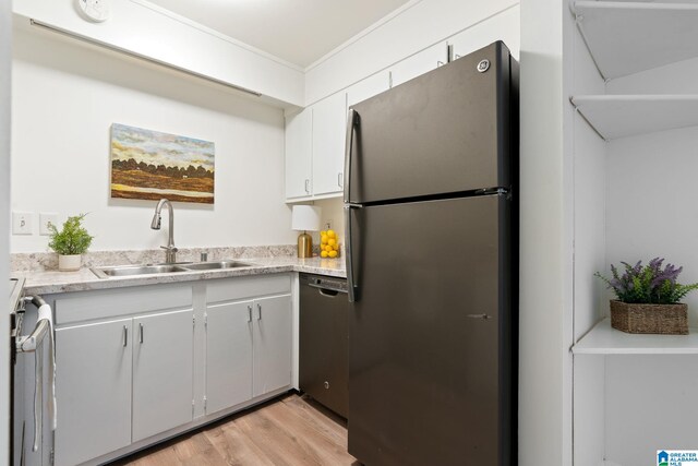 kitchen featuring sink, white cabinets, stainless steel appliances, and light wood-type flooring