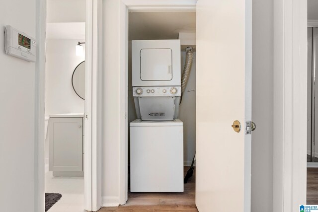 laundry room featuring light hardwood / wood-style floors and stacked washer / dryer