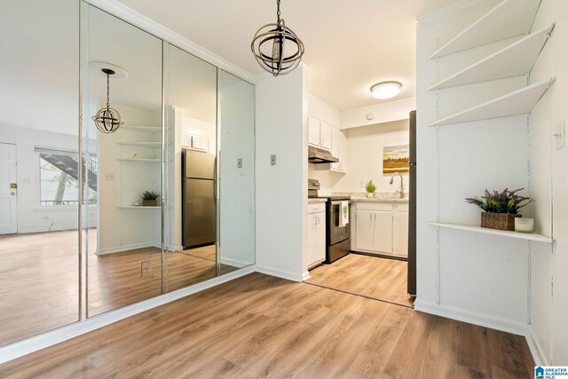 kitchen with white cabinetry, hanging light fixtures, stainless steel appliances, and an inviting chandelier