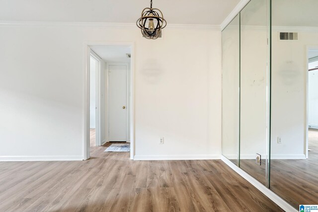 interior space with crown molding, light hardwood / wood-style flooring, and an inviting chandelier