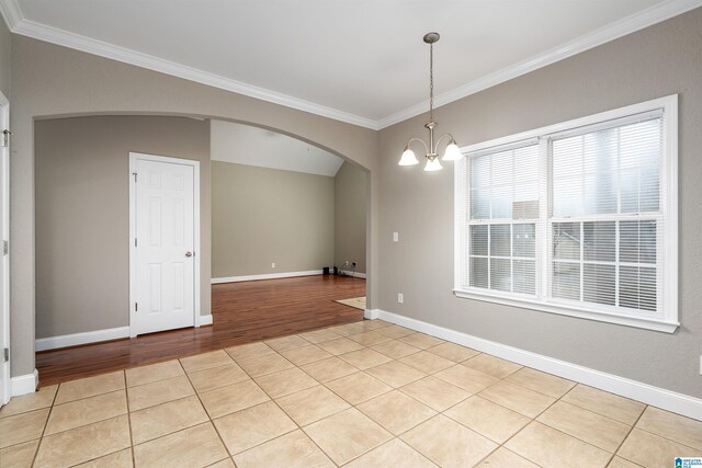 unfurnished room with crown molding, a chandelier, and light wood-type flooring