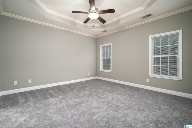 carpeted empty room featuring ceiling fan, a raised ceiling, and crown molding