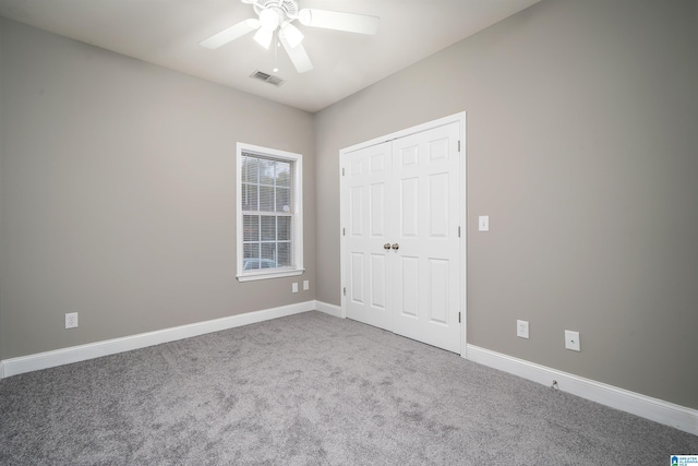 unfurnished bedroom featuring ceiling fan, a closet, and carpet