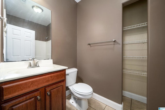 bathroom featuring tile patterned flooring, a shower, vanity, and toilet