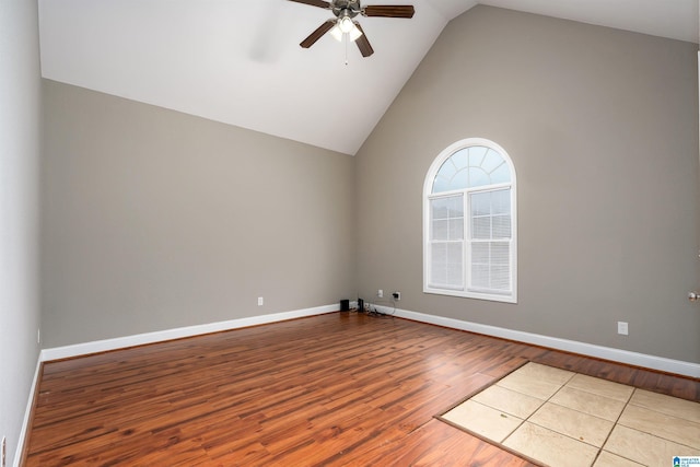 spare room with ceiling fan, light wood-type flooring, and high vaulted ceiling