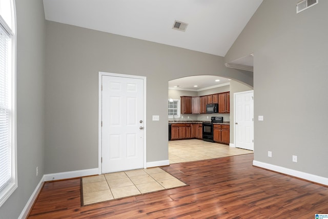 kitchen featuring a healthy amount of sunlight, light hardwood / wood-style flooring, and black appliances