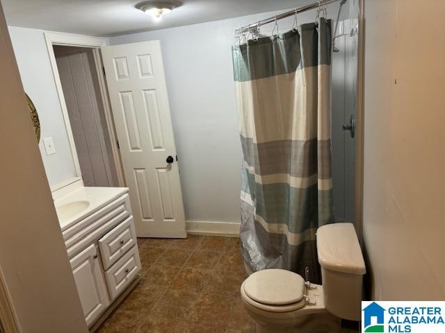 bathroom featuring a shower with shower curtain, vanity, and toilet