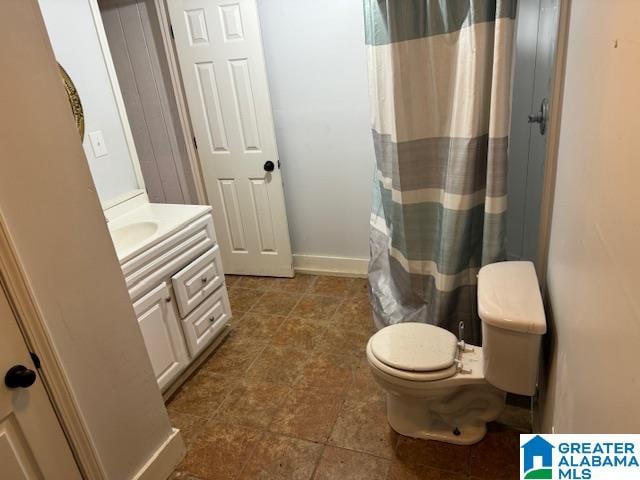 bathroom featuring curtained shower, vanity, and toilet