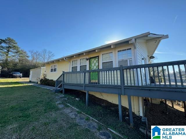 rear view of house with a yard and a deck