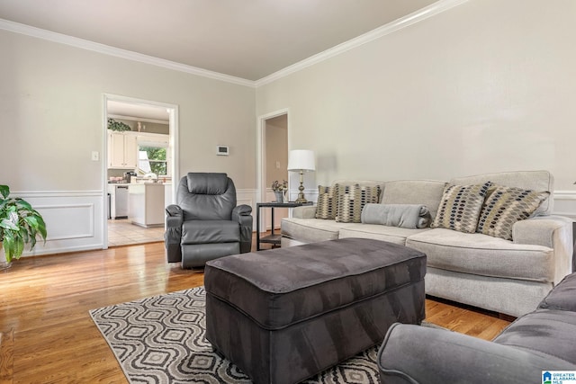 living room with light wood-type flooring and ornamental molding