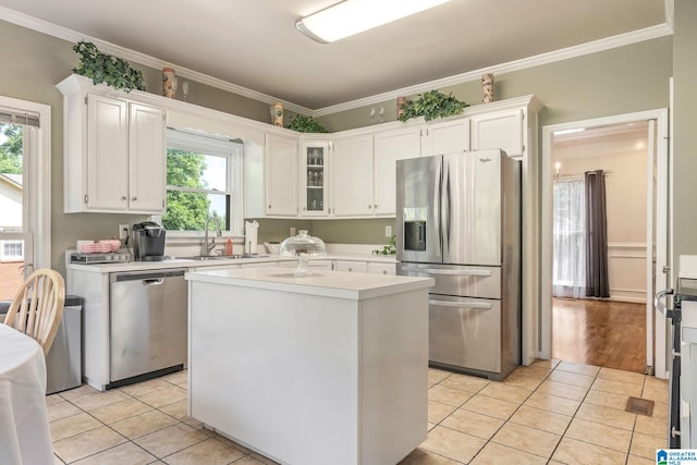 kitchen featuring a center island, stainless steel appliances, white cabinetry, and a healthy amount of sunlight