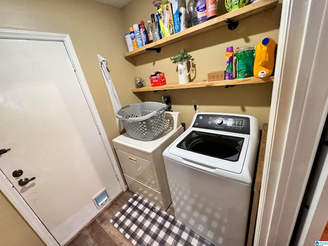 clothes washing area featuring washing machine and dryer and hardwood / wood-style flooring