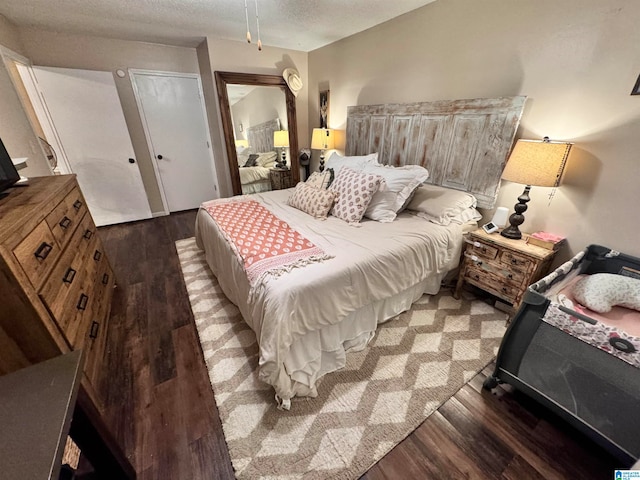 bedroom featuring a textured ceiling and dark wood-type flooring