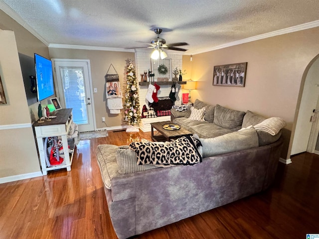 living room featuring ceiling fan, hardwood / wood-style floors, a textured ceiling, and ornamental molding