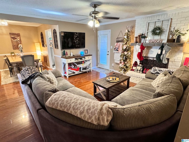 living room with ceiling fan, hardwood / wood-style floors, a textured ceiling, and ornamental molding