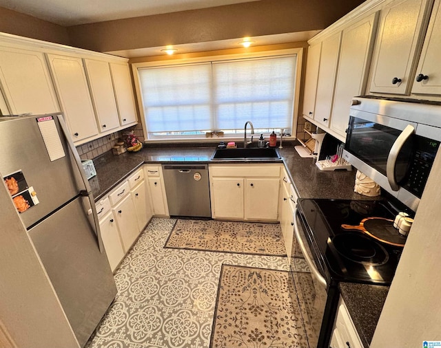 kitchen featuring white cabinets, stainless steel appliances, tasteful backsplash, and sink