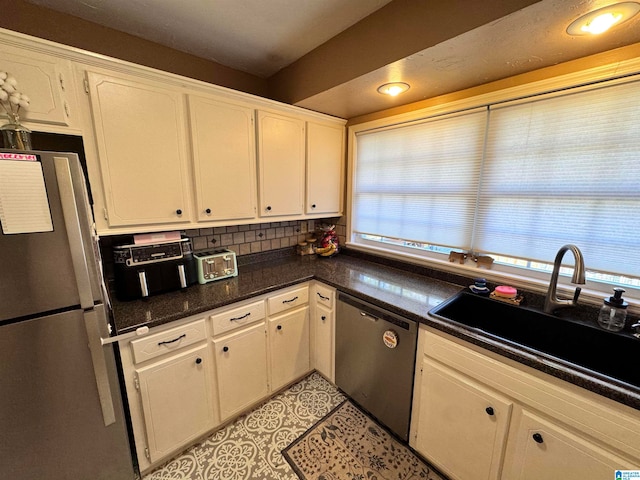 kitchen featuring white cabinetry, sink, appliances with stainless steel finishes, and tasteful backsplash