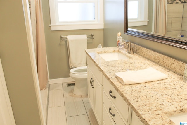 bathroom with vanity, toilet, and plenty of natural light