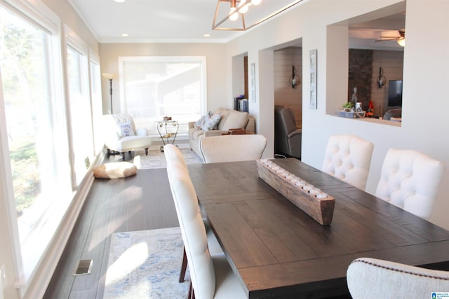 dining room with ceiling fan with notable chandelier and ornamental molding