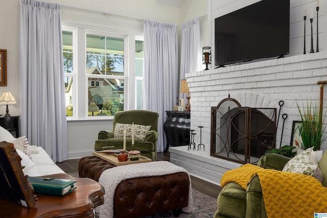 living area featuring dark hardwood / wood-style floors and a brick fireplace