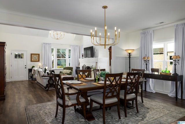 dining space featuring a healthy amount of sunlight, dark hardwood / wood-style flooring, crown molding, and a chandelier