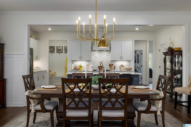 dining room with dark hardwood / wood-style floors, crown molding, and a notable chandelier