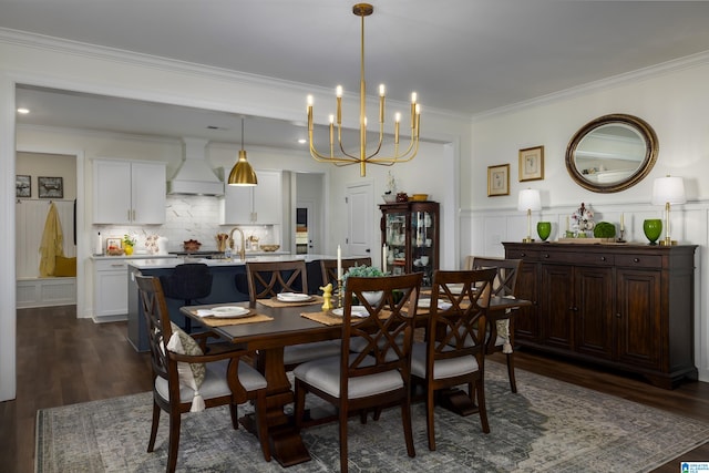 dining room featuring crown molding, sink, a chandelier, and dark hardwood / wood-style floors