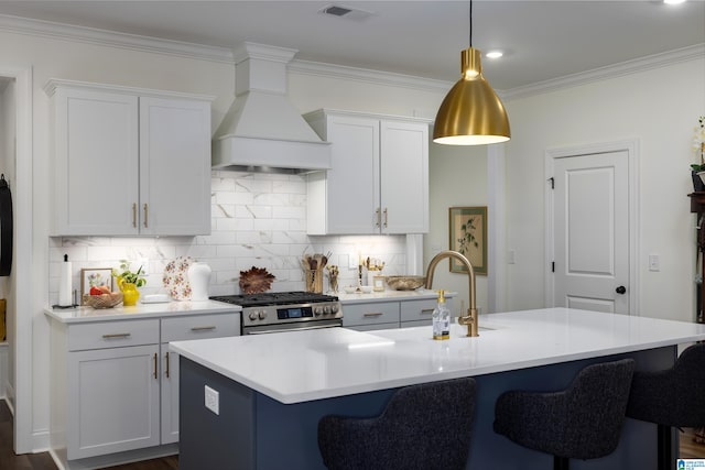 kitchen with white cabinetry, high end range, premium range hood, and an island with sink