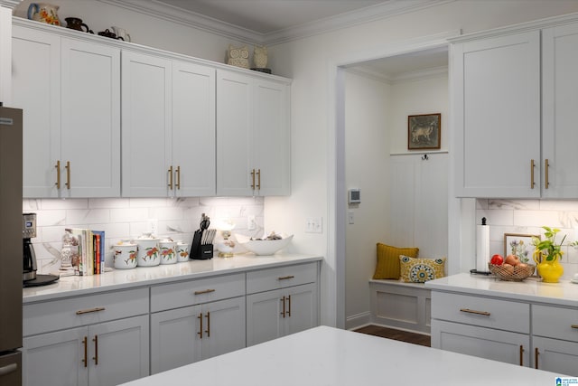 kitchen featuring white cabinets, dark hardwood / wood-style flooring, tasteful backsplash, and crown molding