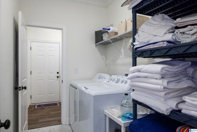 laundry area with light wood-type flooring, separate washer and dryer, and ornamental molding