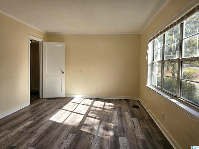 empty room featuring dark hardwood / wood-style flooring, ornamental molding, and a wealth of natural light