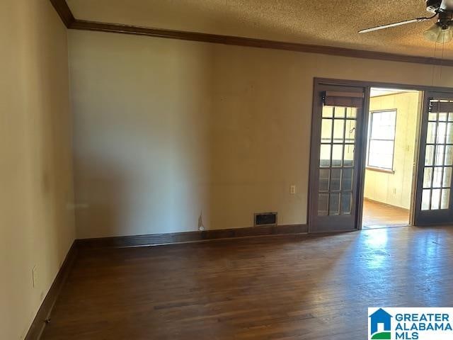 spare room featuring hardwood / wood-style floors, ceiling fan, ornamental molding, and a textured ceiling