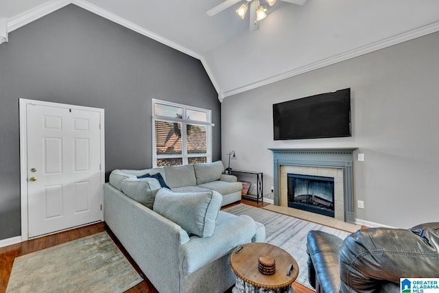 living room with hardwood / wood-style floors, crown molding, a fireplace, and vaulted ceiling