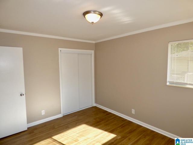 unfurnished bedroom with hardwood / wood-style floors, a closet, and ornamental molding