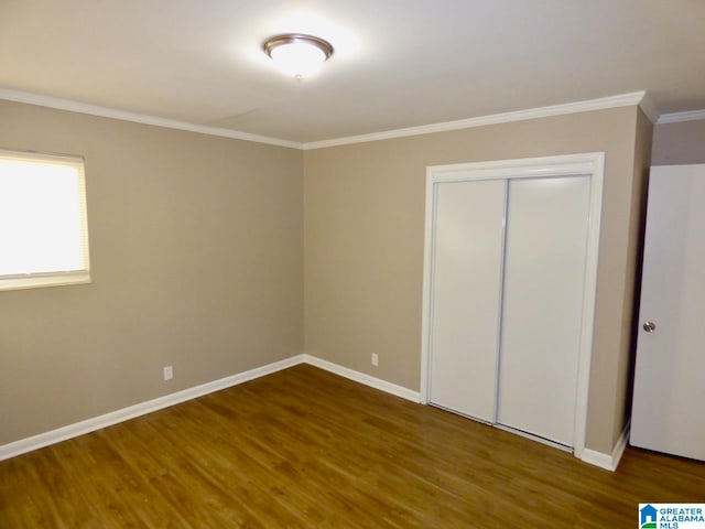 unfurnished bedroom featuring hardwood / wood-style floors, a closet, and crown molding