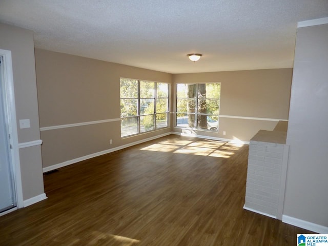 empty room featuring dark hardwood / wood-style floors and a textured ceiling