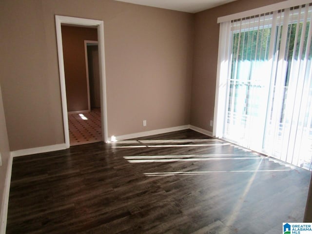 empty room with dark hardwood / wood-style flooring