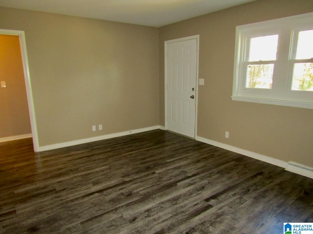 unfurnished room with dark wood-type flooring