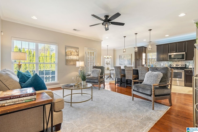 living room with crown molding, light hardwood / wood-style flooring, and ceiling fan