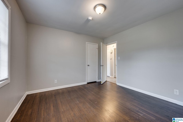 spare room featuring dark wood-type flooring