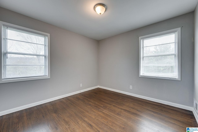 empty room with dark hardwood / wood-style flooring