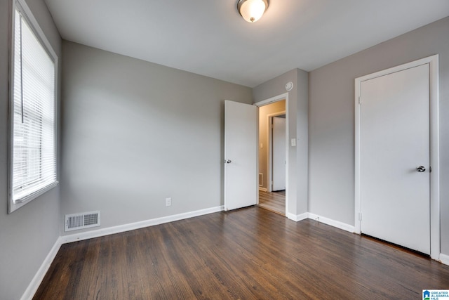 unfurnished bedroom with dark hardwood / wood-style flooring