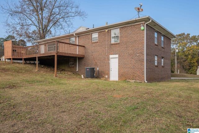 rear view of house featuring central AC, a deck, and a lawn