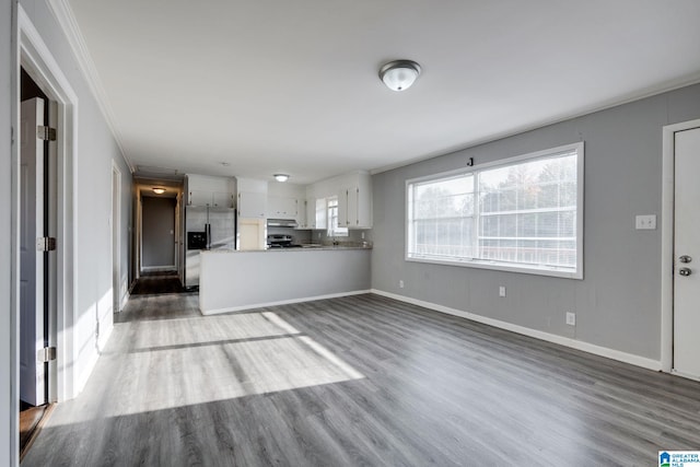 unfurnished living room featuring dark hardwood / wood-style flooring and crown molding