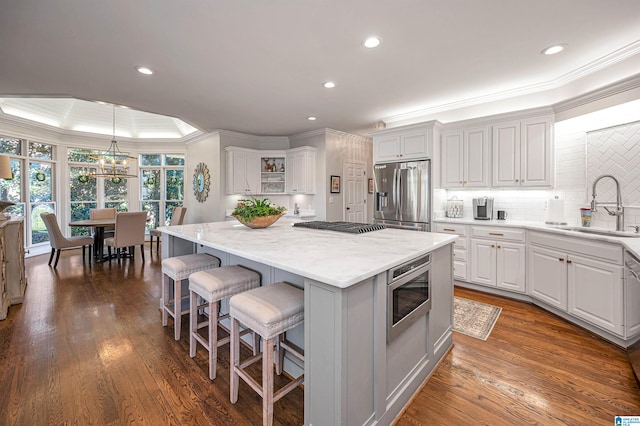 kitchen featuring a center island, stainless steel appliances, white cabinetry, and sink