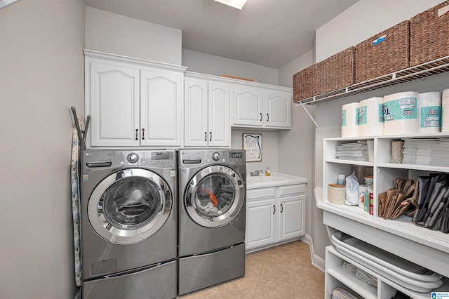 clothes washing area featuring cabinets, separate washer and dryer, sink, and light tile patterned floors