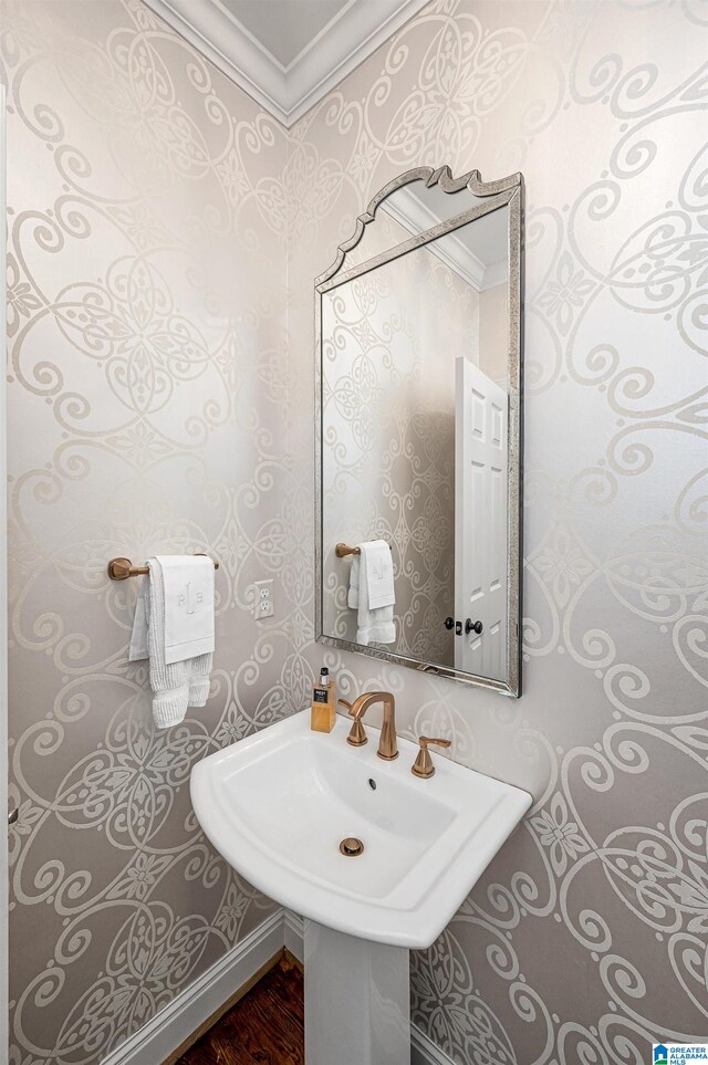 bathroom featuring hardwood / wood-style floors, sink, and crown molding