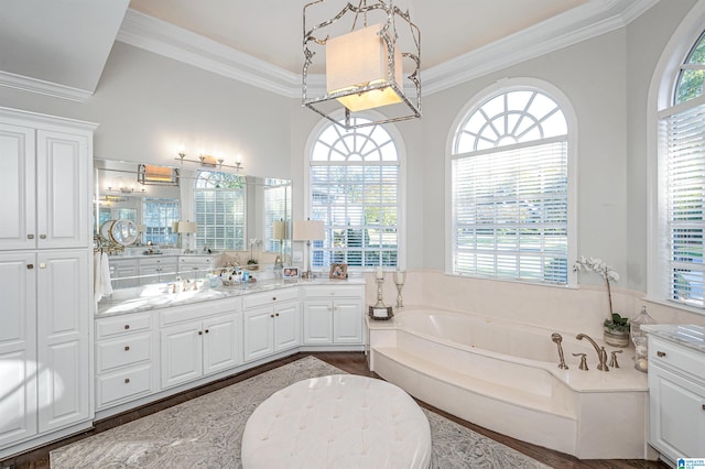 bathroom with hardwood / wood-style floors, vanity, ornamental molding, and a tub to relax in