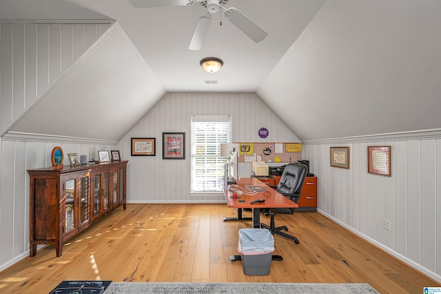 home office with ceiling fan, wooden walls, vaulted ceiling, and light wood-type flooring