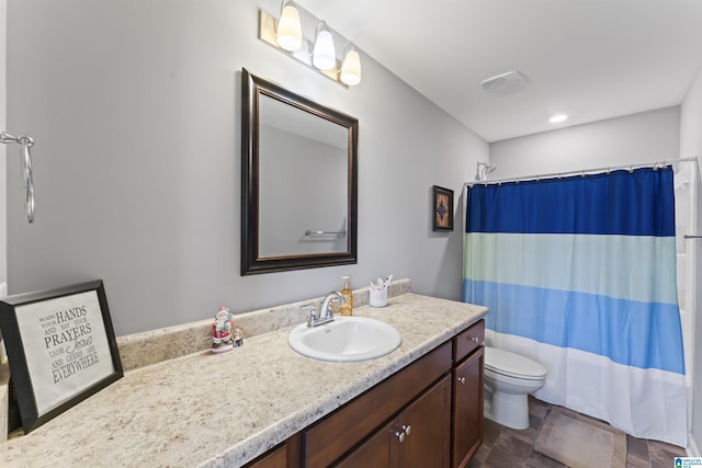 bathroom featuring vanity, toilet, and walk in shower